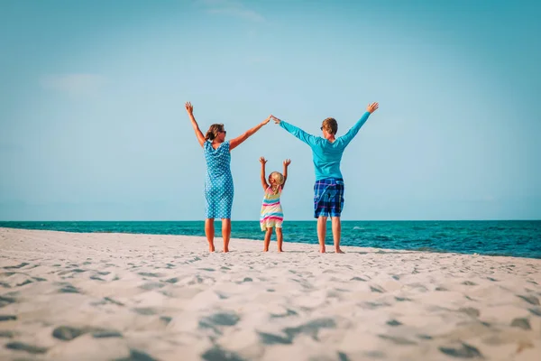 Familia feliz con hija pequeña jugar en la playa tropical — Foto de Stock