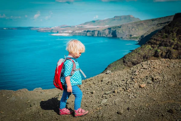 Маленькая девочка с рюкзаком походы в горы на море — стоковое фото