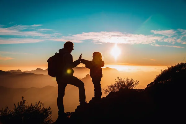 Счастливый отец и маленькая дочь путешествуют в горах на закате — стоковое фото
