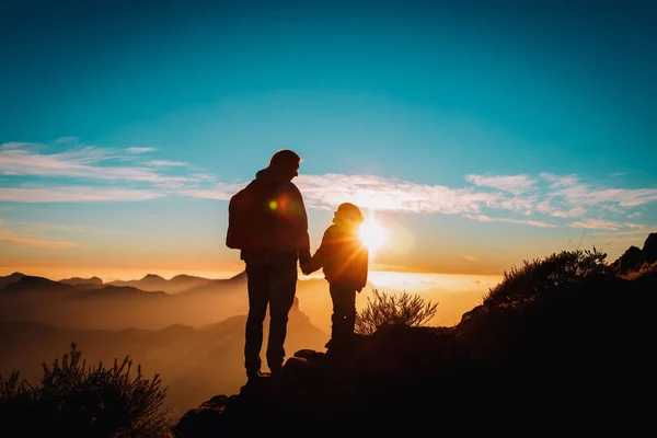 Otec a dcera malá cestovat v horách při západu slunce — Stock fotografie