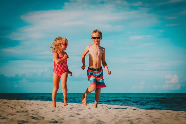 Маленький мальчик и девочка бегают играть на пляже — стоковое фото