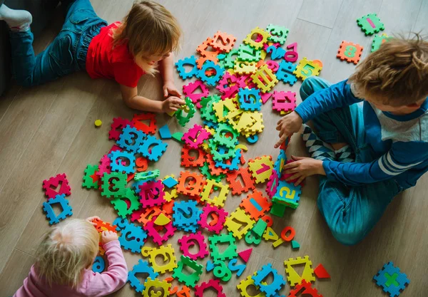 Enfants jouant avec puzzle, apprendre des nombres et des formes — Photo