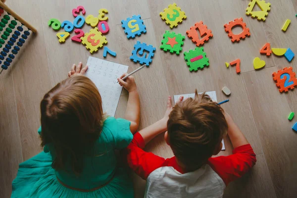 Niños-niño y niña-aprender a escribir y calcular números — Foto de Stock