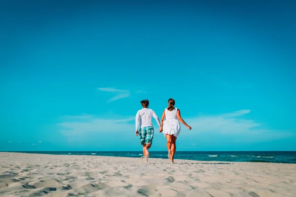 Lyckliga älskande par körning lek njuta av tropisk strand — Stockfoto