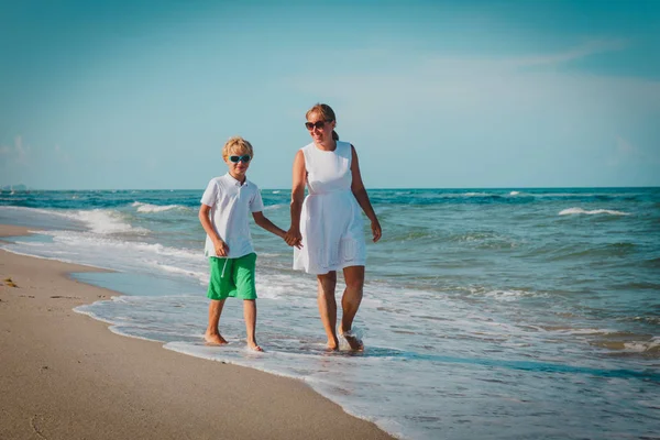 Ευτυχισμένη μητέρα και γιος με τα πόδια σε τροπική παραλία — Φωτογραφία Αρχείου