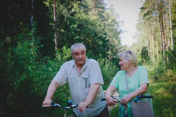 active senior couple riding bikes in nature