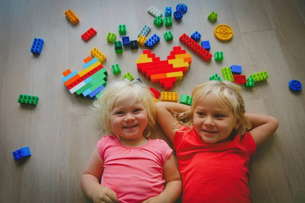 Meninas bonitos felizes gostam de brincar com blocos de plástico — Fotografia de Stock