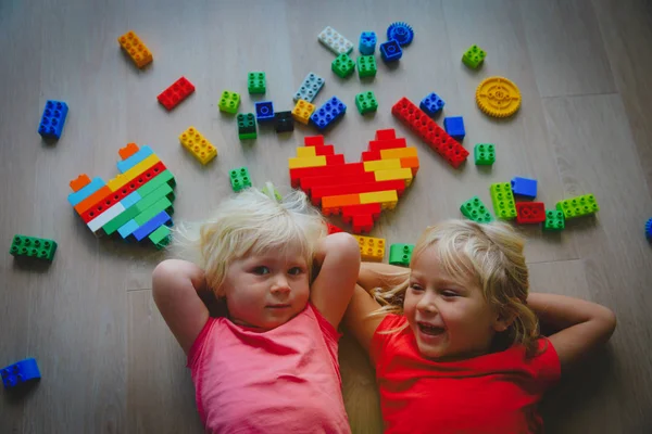 Meninas bonitos felizes gostam de brincar com blocos de plástico — Fotografia de Stock