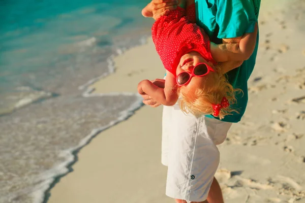 Отец и маленькая дочь играют на пляже — стоковое фото