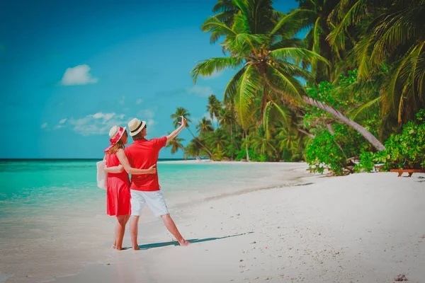 Joven feliz pareja haciendo un selfie en playa — Foto de Stock