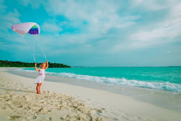 Carino felice bambina volare un aquilone in cielo sulla spiaggia — Foto Stock