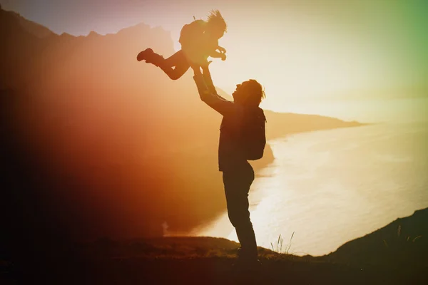 Pai feliz e pequena filha viajam nas montanhas ao pôr do sol — Fotografia de Stock