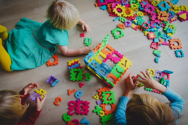 Crianças brincando com número e formas quebra-cabeça — Fotografia de Stock