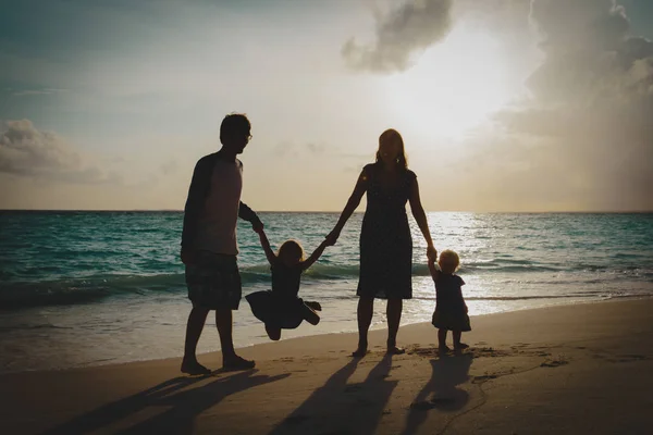 Família feliz com crianças em jogo na praia do por do sol — Fotografia de Stock