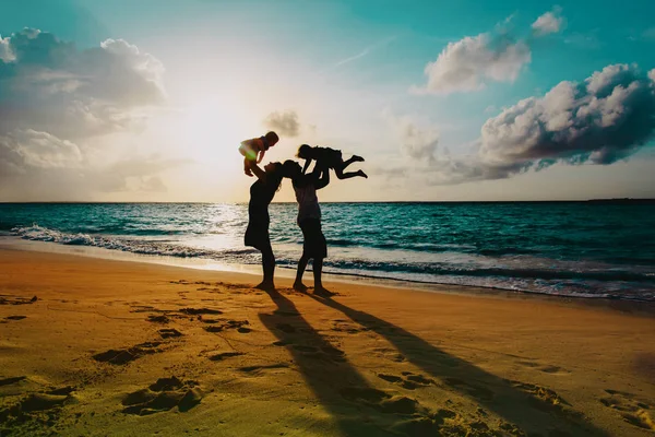 Szczęśliwa rodzina z dziećmi, w play na zachód słońca plaża — Zdjęcie stockowe