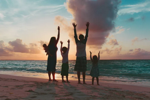 Щаслива сім'я з дітьми розважається на пляжі заходу сонця — стокове фото