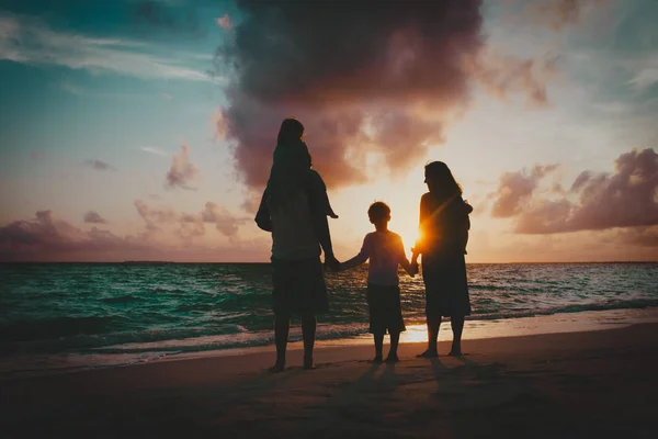 Šťastná rodina s dětmi baví na pláži západ slunce — Stock fotografie