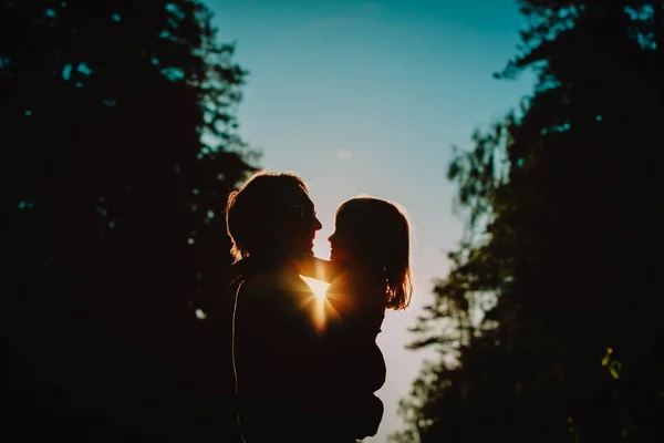 Pai e pequena filha silhuetas jogar ao pôr do sol — Fotografia de Stock