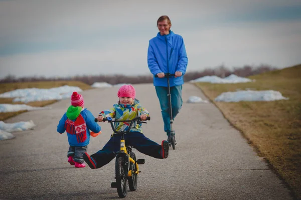 Attivo spor family- padre su schooter con bambini al di fuori, bambina in bicicletta — Foto Stock