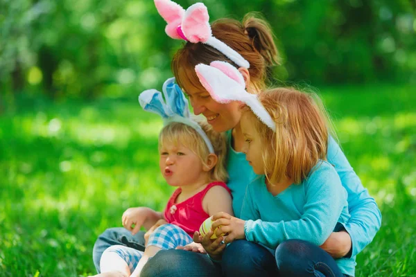 Mãe feliz e crianças em ovos de Páscoa caçam na primavera — Fotografia de Stock