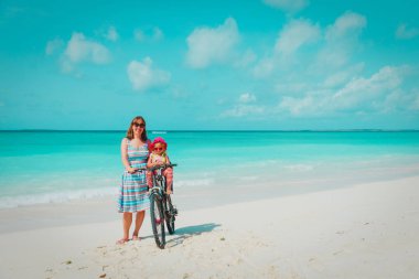 Tatlı küçük bebek kız bisikleti Beach ile mutlu anne