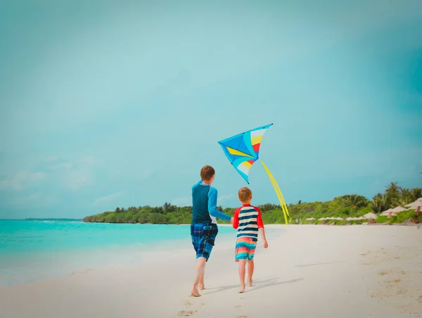 Padre e figlio aquilone volante sulla spiaggia, vacanza in famiglia — Foto Stock