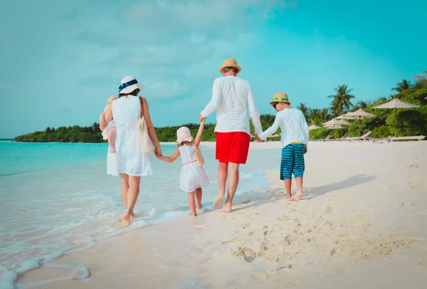 Üç çocuklu mutlu bir aile sahilde yürüyor. — Stok fotoğraf