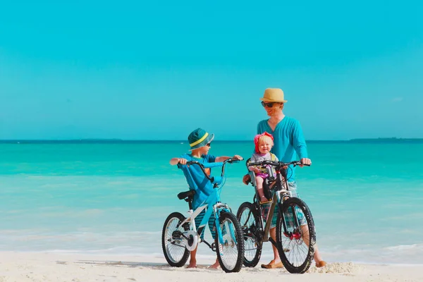 Apja kis fia és lánya kerékpározzon a tengerparton — Stock Fotó
