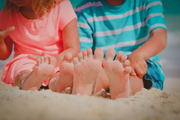 Menino e menina brincam com areia na praia — Fotografia de Stock