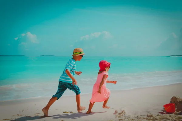Küçük oğlan ve kız koşmak plajda oyna — Stok fotoğraf