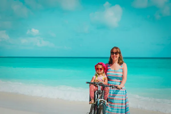 Happy mother with cute little baby girl bike at beach — Stock Photo, Image