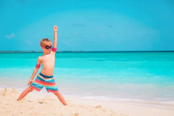 Glücklich niedlichen kleinen Jungen spielen Superhelden am tropischen Strand — Stockfoto