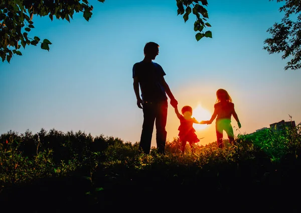 父亲与二个女儿漫步在日落自然 — 图库照片