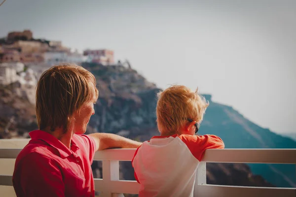 Padre e hijo pequeño mirando caldera en Santorini, Grecia —  Fotos de Stock