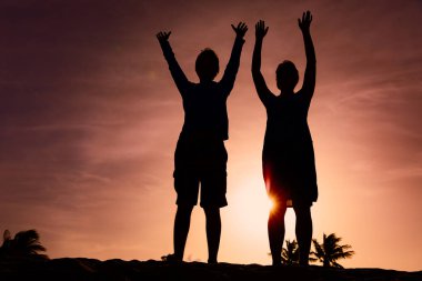 Mutlu çift gün batımının tadını çıkarın. Aile elleri gökyüzünde.