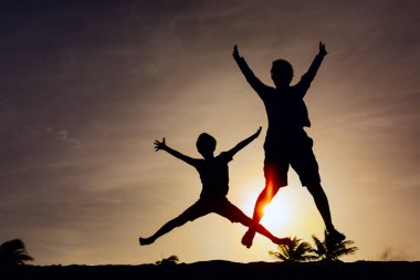 Baba ve oğul oyun günbatımı Plajı'nda Aile keyfini çıkarın tatil tropikal