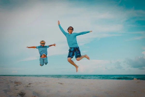 Šťastný otec a syn mají zábavu na pláži, rodinné skok na písku — Stock fotografie