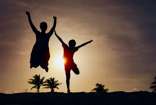 Mãe e filho brincam ao pôr do sol, família desfrutar de férias tropicais — Fotografia de Stock