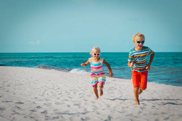 Szczęśliwy kids chłopiec i dziewczynka działa na plaży — Zdjęcie stockowe