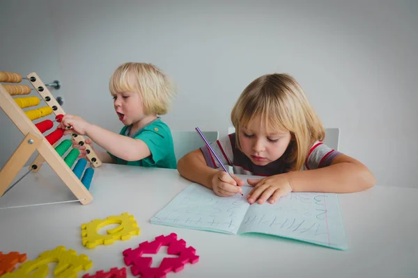 Niñas aprenden a escribir y a culcular números — Foto de Stock
