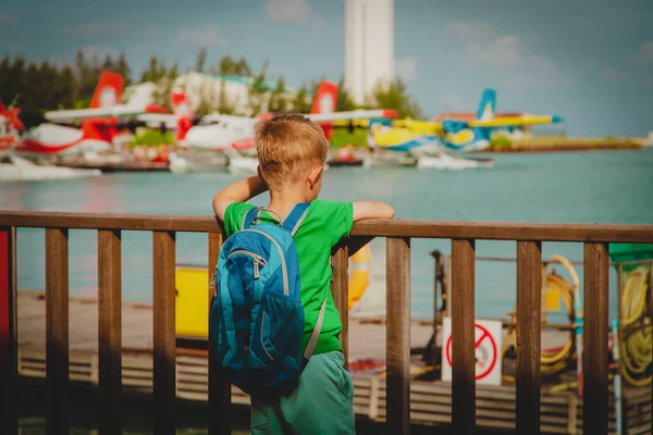 Маленький мальчик смотрит на гидросамолеты на Мальдивах — стоковое фото