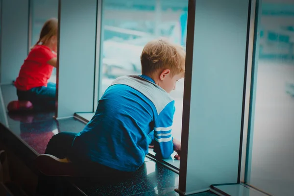 Маленький хлопчик і дівчинка чекають літака в аеропорту — стокове фото