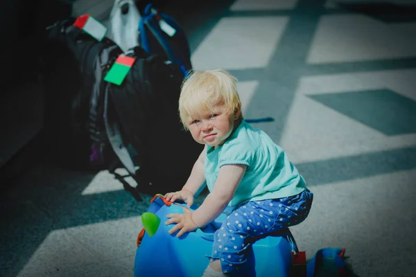 Schattige kleine baby met rugzak en koffer wachten in de luchthaven, familie reizen — Stockfoto