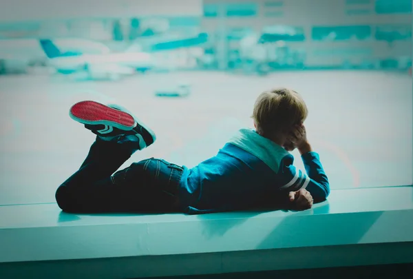 Маленький хлопчик дивиться на літаки в аеропорту, діти подорожують концепцією — стокове фото