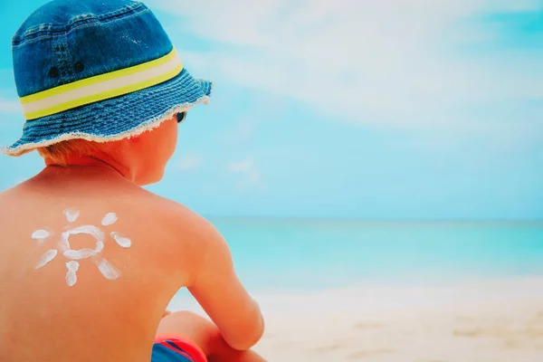 Sun protection - mały chłopiec z suncream na tropikalnej plaży — Zdjęcie stockowe