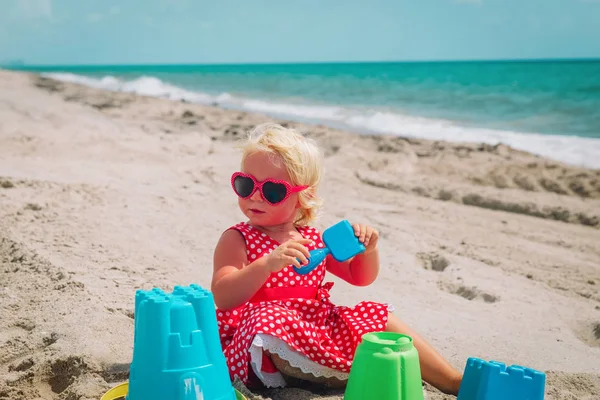 Мила маленька дівчинка грає з піском на пляжі — стокове фото
