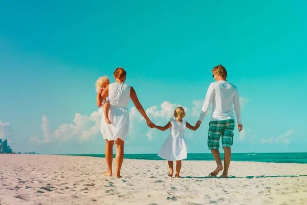 Gezin met twee kinderen lopen op tropisch strand — Stockfoto