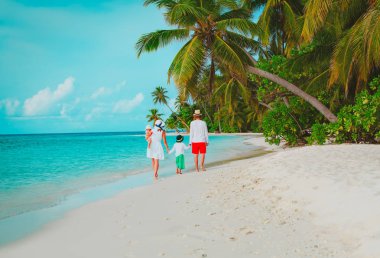 Kumsalda yürüyen iki çocuklu genç aile