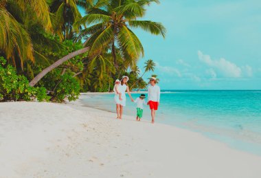 Kumsalda yürüyen iki çocuklu mutlu aile