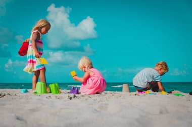 Çocuk kum ile kumsalda kumdan kale Bina aile oyun.